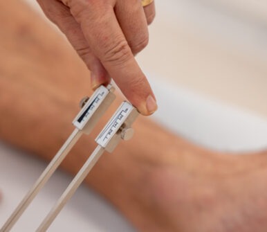 Lékař používá ladičku k testování citlivosti pacienta na noze při neurologickém vyšetření.